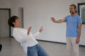 Real no touch body reaction demonstration with a woman losing balance while a man focuses intention without physical contact.